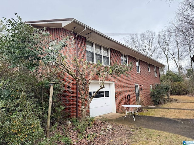 view of home's exterior featuring brick siding and an attached garage