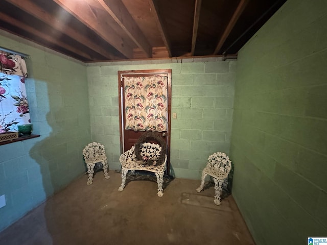 sitting room with concrete block wall and concrete floors