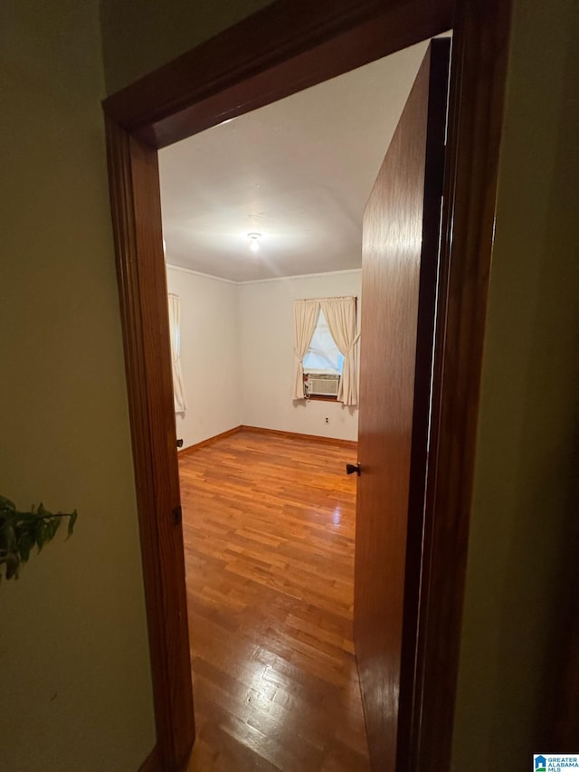 corridor with baseboards, cooling unit, and wood finished floors