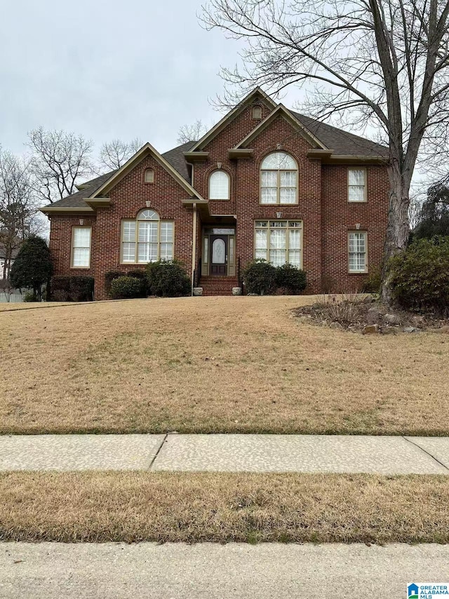 view of front facade with a front yard and brick siding