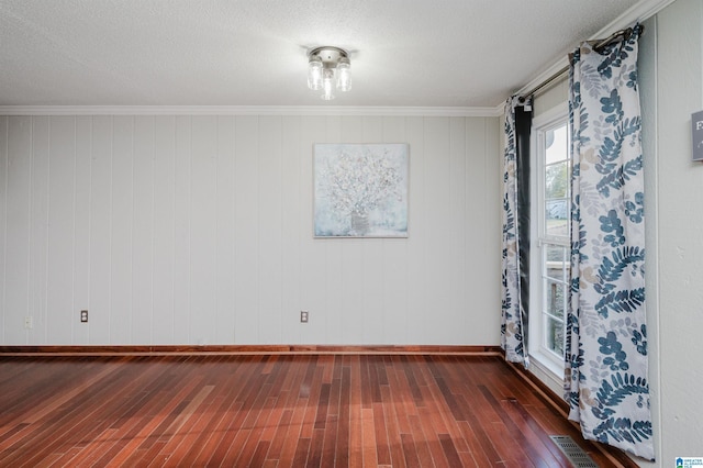 spare room with visible vents, baseboards, dark wood finished floors, and a textured ceiling