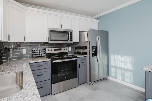 kitchen featuring tasteful backsplash, appliances with stainless steel finishes, white cabinets, and crown molding