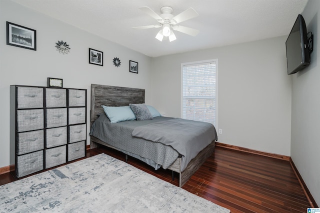 bedroom featuring wood finished floors, a ceiling fan, and baseboards