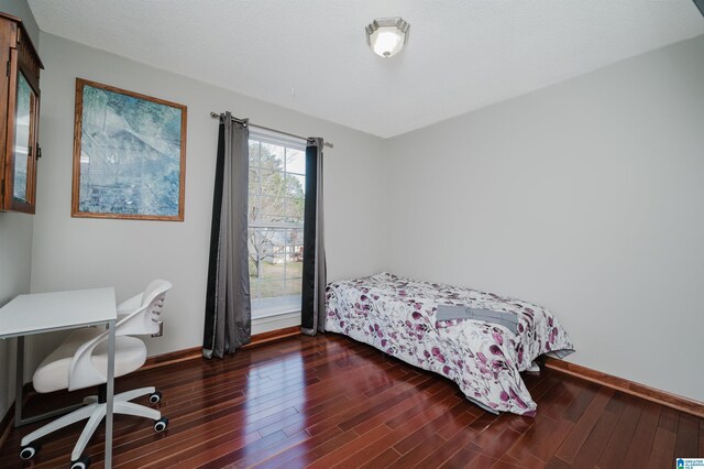 bedroom featuring baseboards and wood finished floors