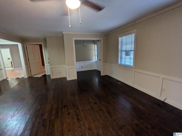 unfurnished living room featuring wainscoting, dark wood finished floors, and a decorative wall