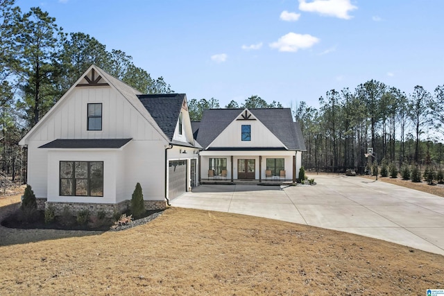 modern farmhouse style home featuring a garage, concrete driveway, roof with shingles, and covered porch