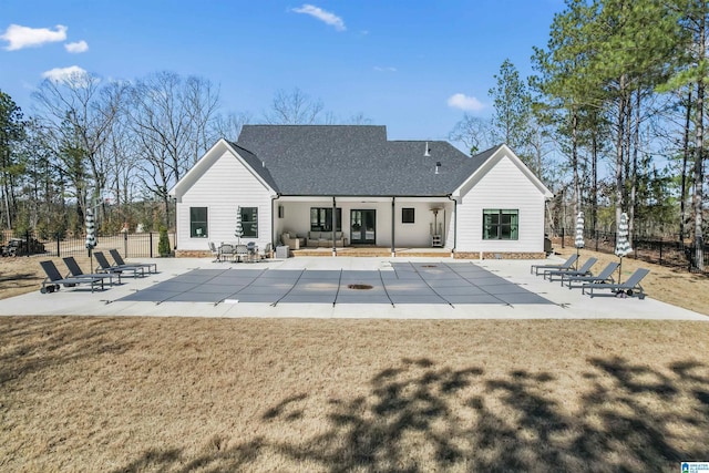 back of house featuring a patio, a lawn, fence, and a fenced in pool