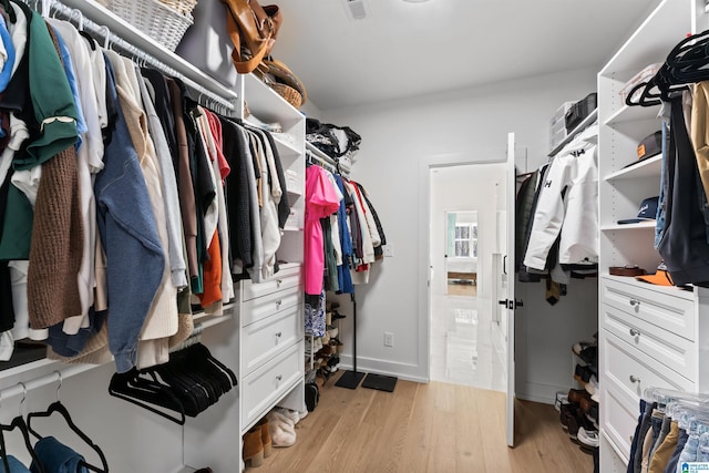 walk in closet with light wood-style flooring