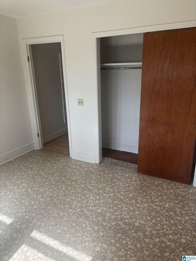 unfurnished bedroom featuring a closet and baseboards