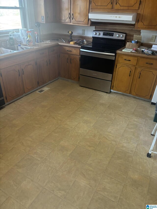 kitchen featuring extractor fan, brown cabinets, visible vents, and stainless steel electric stove