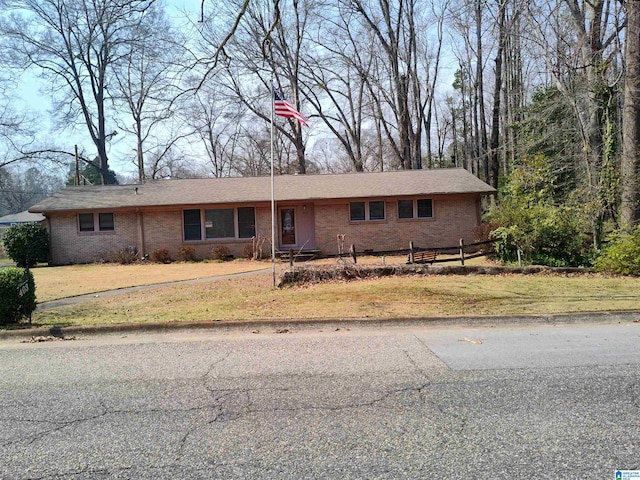 view of front of house with a front yard, fence, and brick siding