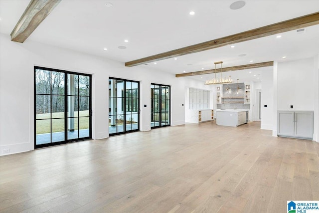 unfurnished living room with baseboards, beamed ceiling, recessed lighting, light wood-style flooring, and an inviting chandelier