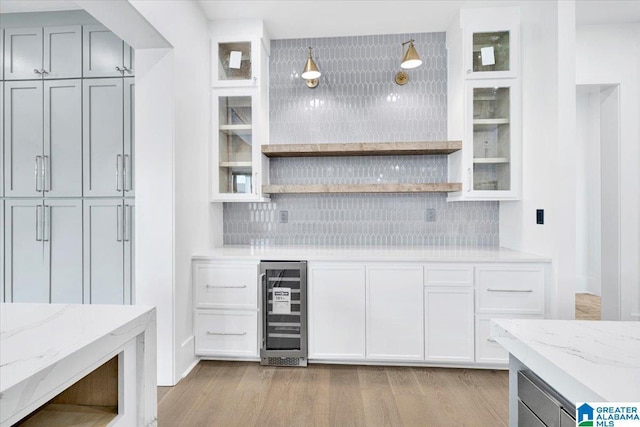 kitchen featuring beverage cooler, backsplash, light wood-style floors, and open shelves