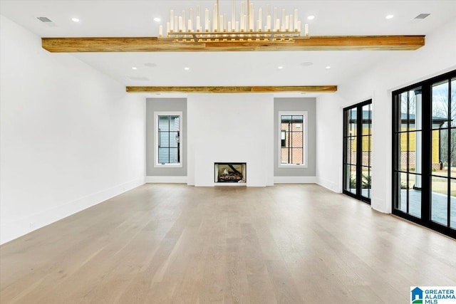 unfurnished living room featuring wood finished floors, a fireplace, baseboards, and a wealth of natural light