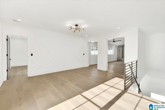 empty room with recessed lighting, wood finished floors, visible vents, and baseboards