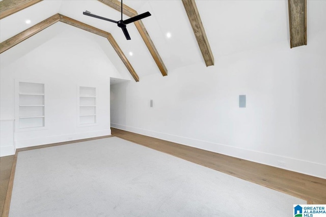 interior space with beam ceiling, high vaulted ceiling, built in features, wood finished floors, and baseboards