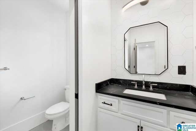 bathroom with tasteful backsplash, toilet, and vanity