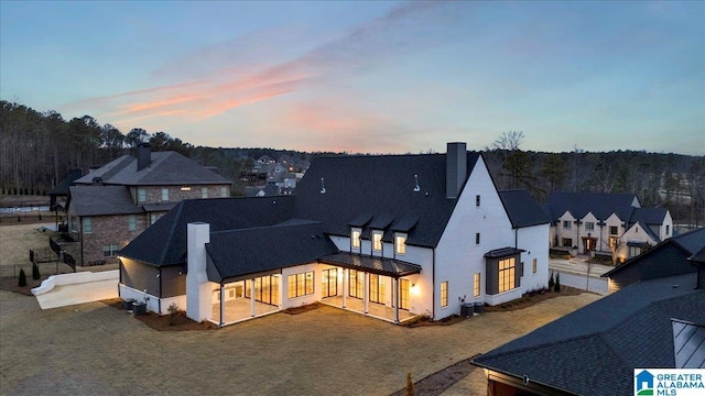 back of property with cooling unit, a chimney, and fence