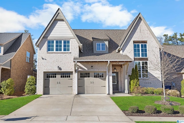 view of front of property featuring driveway, a garage, brick siding, roof with shingles, and a front yard