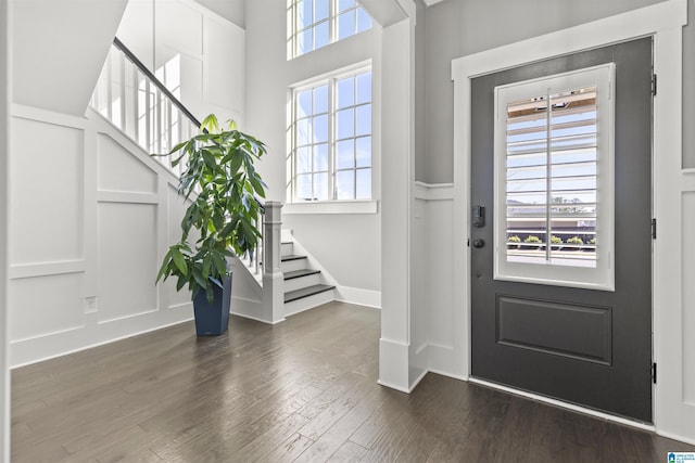 foyer with plenty of natural light, a decorative wall, and stairs