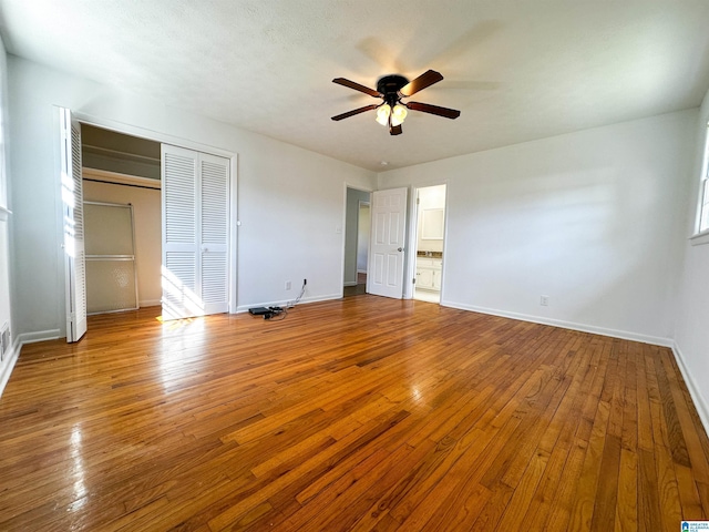 unfurnished bedroom featuring a closet, a ceiling fan, baseboards, and wood-type flooring