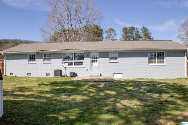 back of house with roof with shingles, a yard, central AC, crawl space, and brick siding