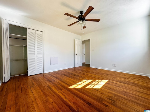 unfurnished bedroom with a closet, baseboards, and hardwood / wood-style floors