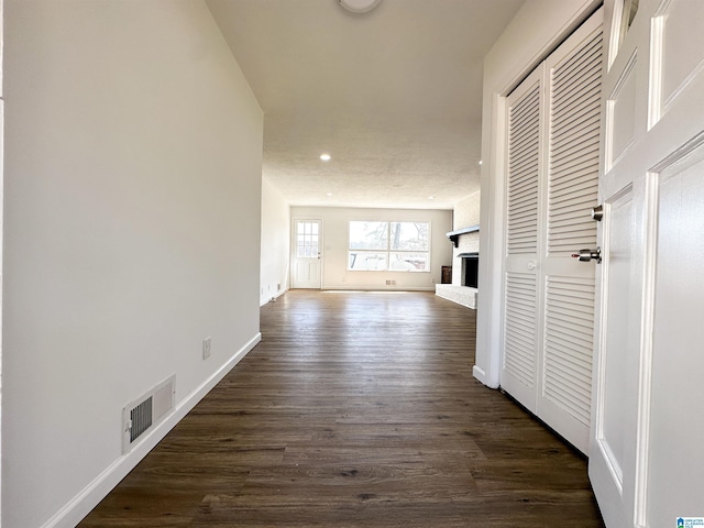 hall with recessed lighting, dark wood-style floors, visible vents, and baseboards