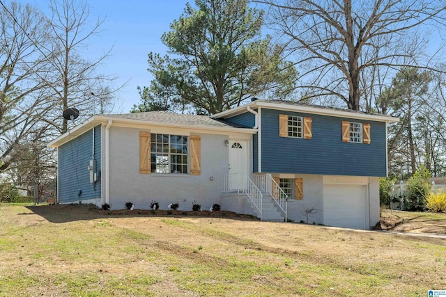 split level home featuring a garage, brick siding, and a front lawn