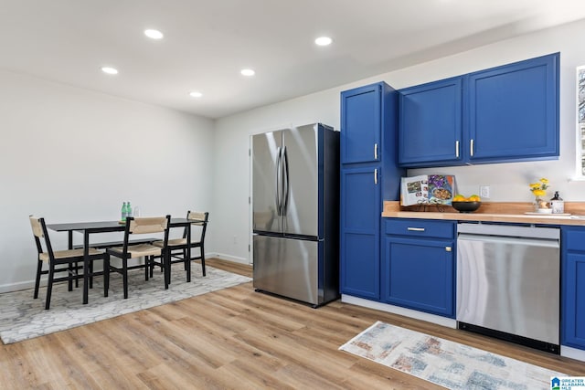 kitchen featuring light countertops, appliances with stainless steel finishes, light wood-style flooring, and blue cabinets