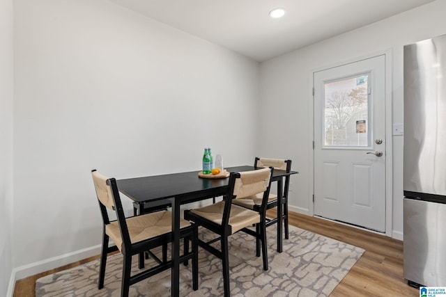 dining space featuring light wood finished floors, baseboards, and recessed lighting