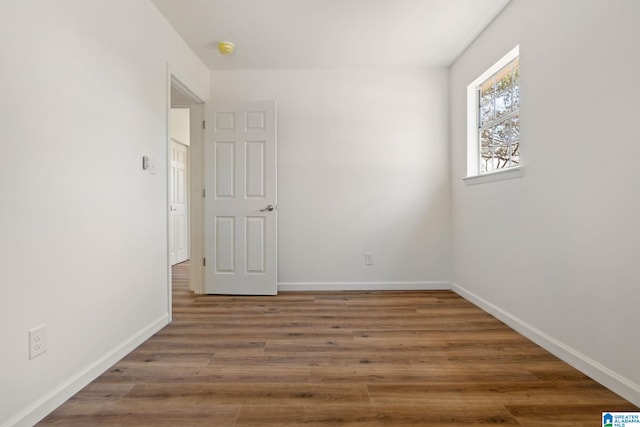 spare room featuring wood finished floors and baseboards