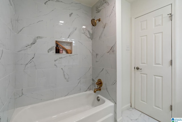 bathroom featuring marble finish floor and bathing tub / shower combination