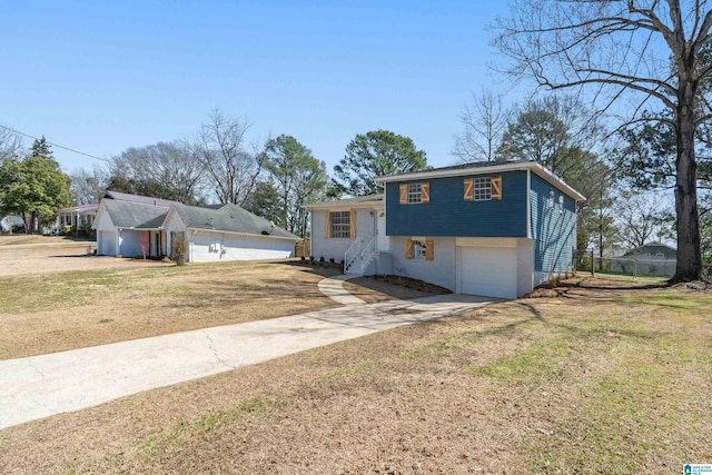 tri-level home with a garage, driveway, and a front yard