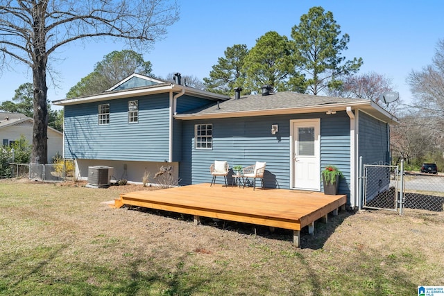 rear view of house featuring a gate, fence, a deck, a yard, and central air condition unit