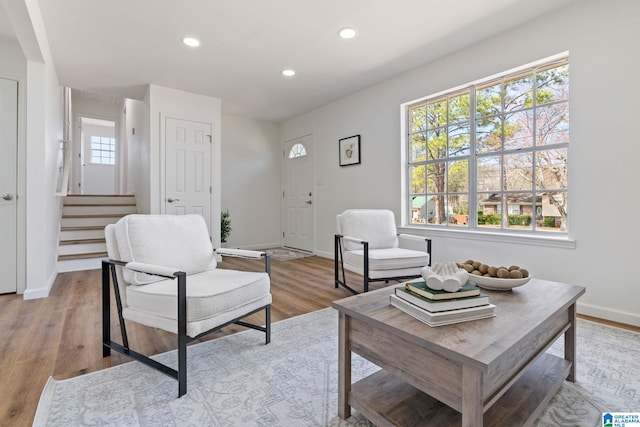 living area with light wood finished floors, stairs, baseboards, and recessed lighting