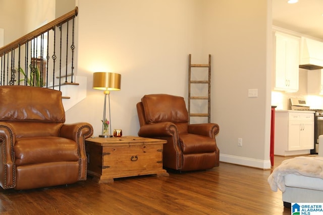 sitting room with stairway, baseboards, and wood finished floors