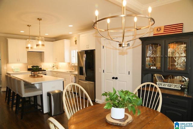 dining area with an inviting chandelier, crown molding, recessed lighting, and dark wood-type flooring