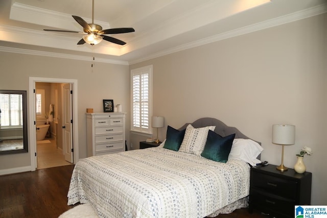 bedroom with a tray ceiling, crown molding, and dark wood-style floors