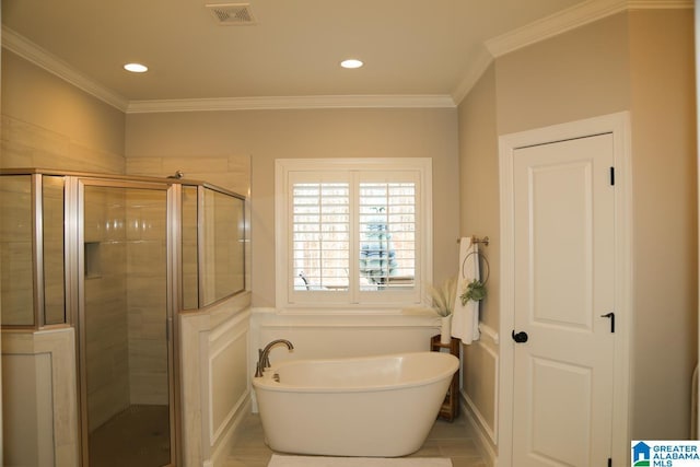 full bath with visible vents, a shower stall, a freestanding bath, and ornamental molding