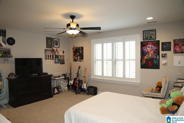 carpeted bedroom with visible vents and a ceiling fan