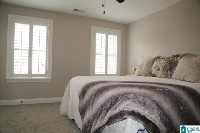 carpeted bedroom with visible vents, ceiling fan, and baseboards