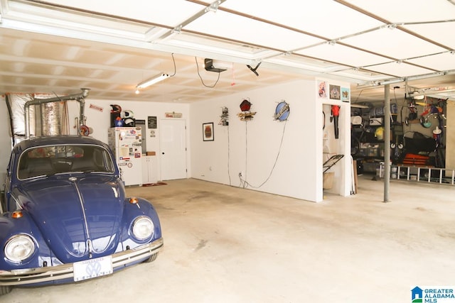 garage with a garage door opener and freestanding refrigerator