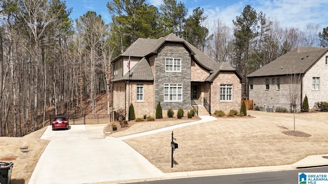 view of front of house with brick siding, stone siding, and a shingled roof