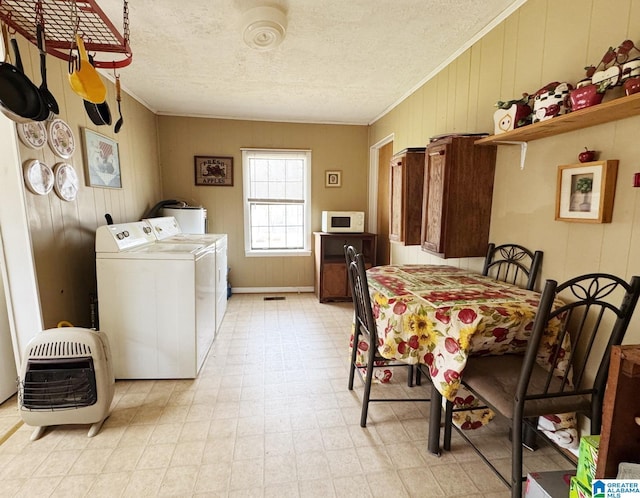 clothes washing area with a textured ceiling, laundry area, washer and dryer, light floors, and crown molding