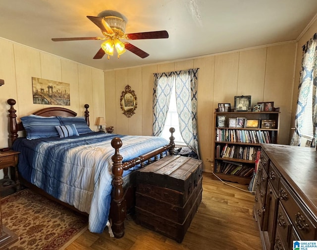 bedroom featuring a ceiling fan, multiple windows, and wood finished floors