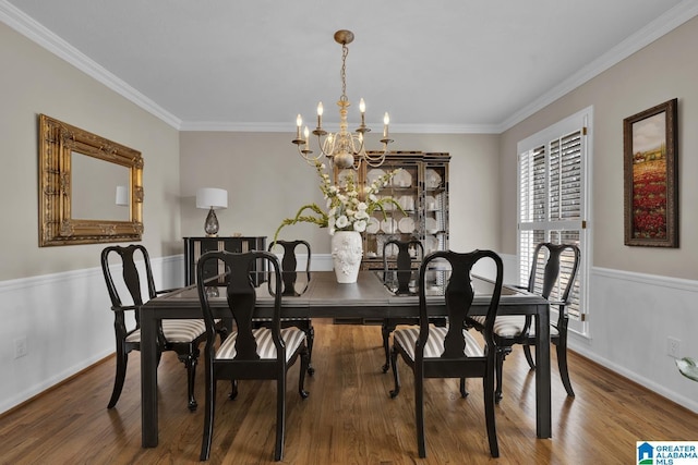 dining room featuring a chandelier, ornamental molding, and wood finished floors