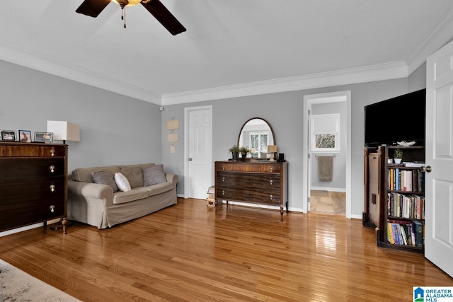 sitting room with light wood finished floors, baseboards, and crown molding