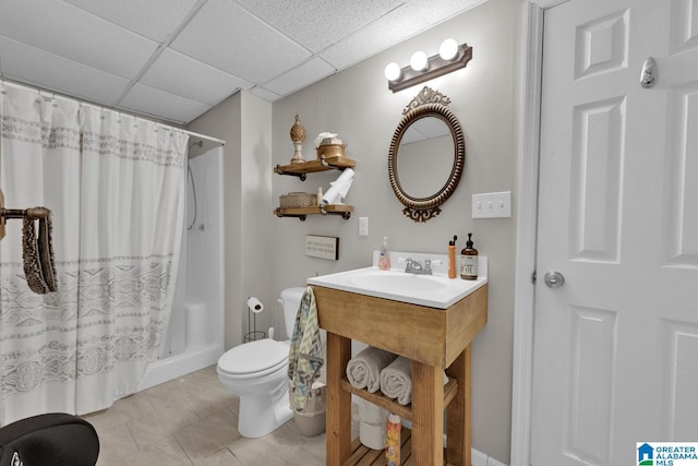 full bathroom with toilet, a shower with shower curtain, tile patterned flooring, and a paneled ceiling