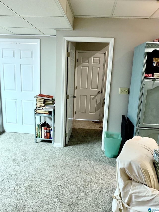 corridor with carpet floors and a paneled ceiling